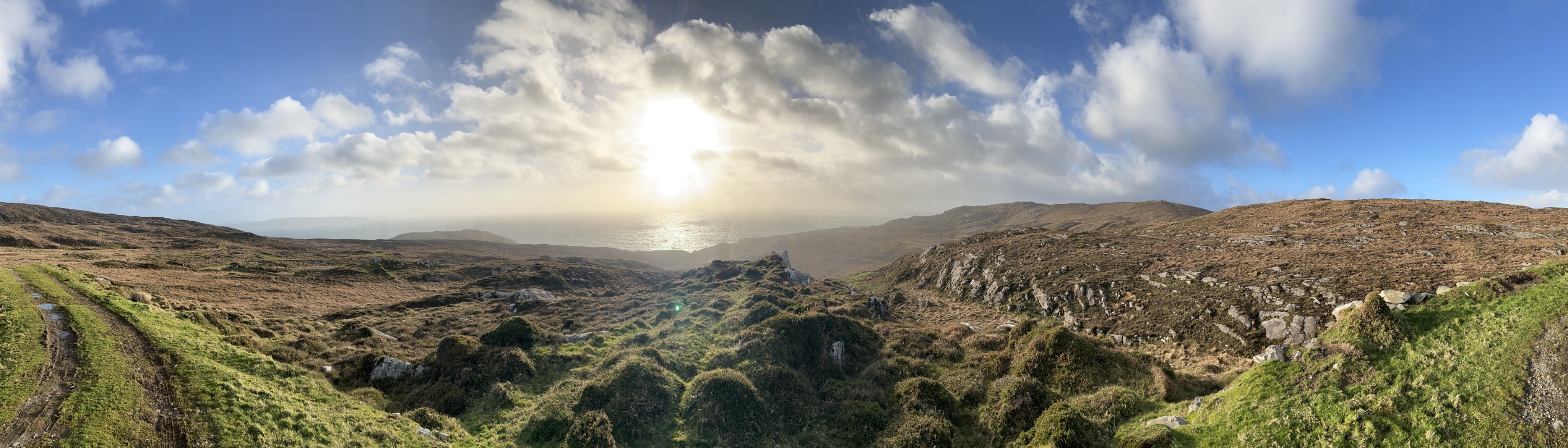 Panorama over the Beara peninsula, sun low over the Atlantic
